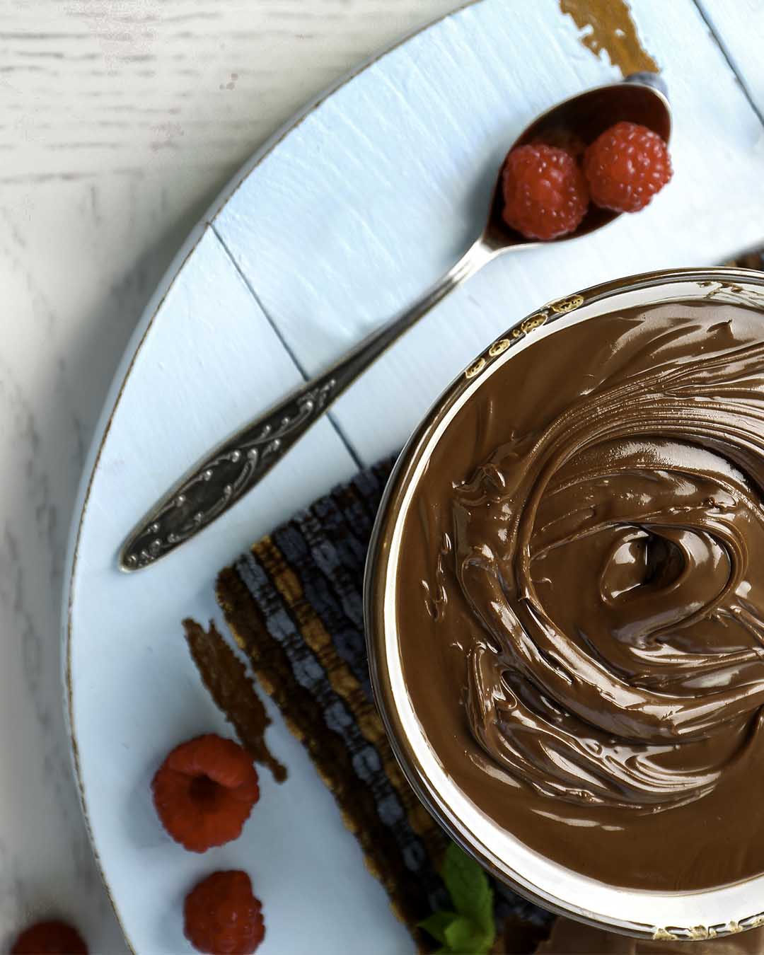 melted chocolate in bowl with raspberries