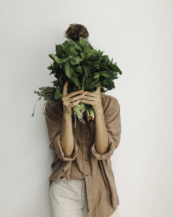 girl with greens in front of her face