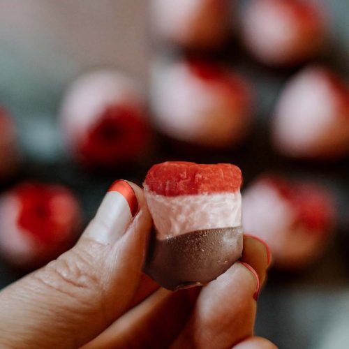 holding chocolate covered rasberry